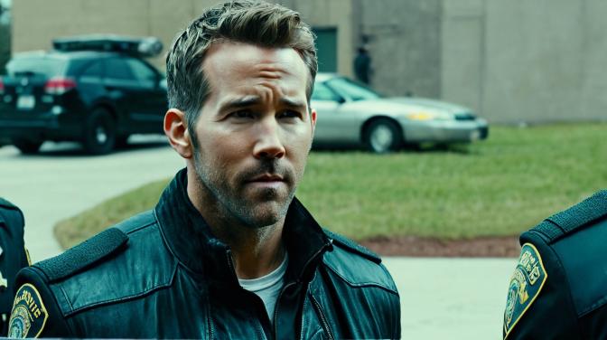 Ryan Reynolds kissing Ryan Reynolds with cocaine cops in the background.