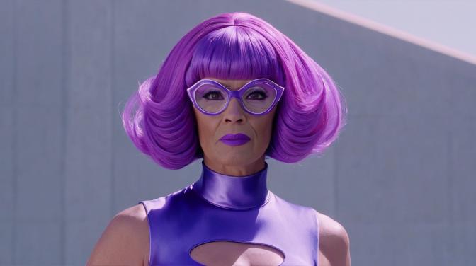 Omni-Man from Invincible dressed in a purple dress and pink wig.